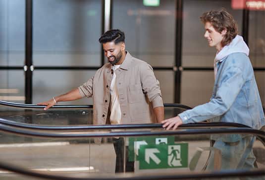 img_two_men_entering_escalator_535x365