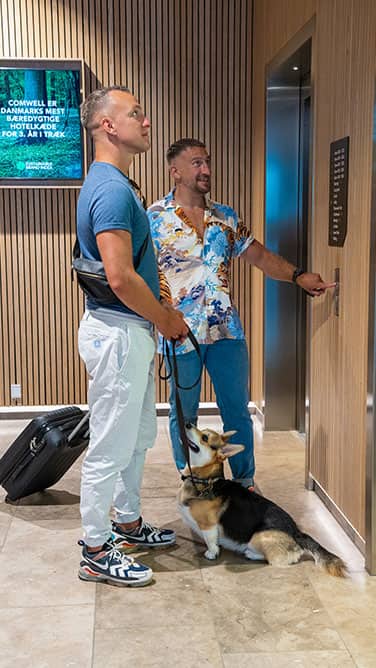 img_two_men_with_dog_waiting_for_elevator_376x668